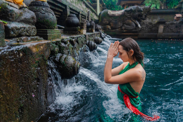 istock Woman doing purifying ritual in  Tirta Empul holy spring 2052071348