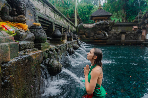 istock Woman doing purifying ritual in  Tirta Empul holy spring 2052074460