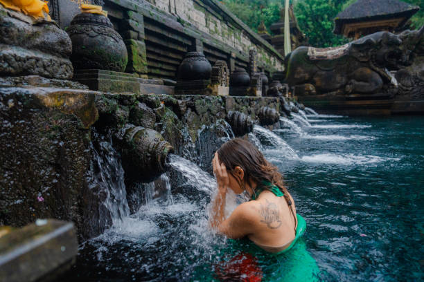 istock Woman doing purifying ritual in  Tirta Empul holy spring 2052074461