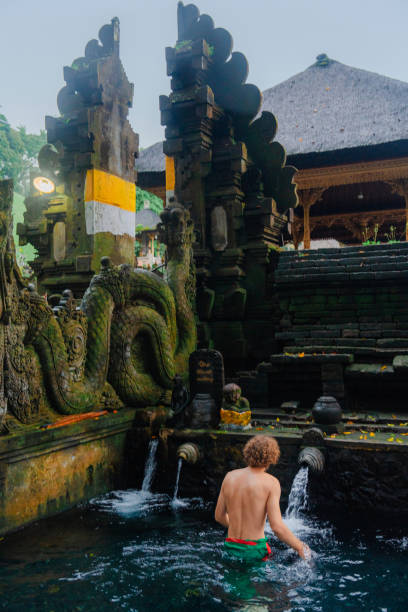 istock Man doing purifying ritual in Tirta empul holy spring, Ubud 2052077595