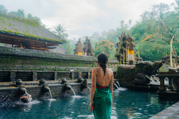 istock Woman doing purifying ritual in  Tirta Empul holy spring 2052081729