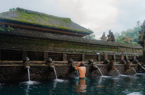 istock Man doing purifying ritual in Tirta empul holy spring, Ubud 2052081730