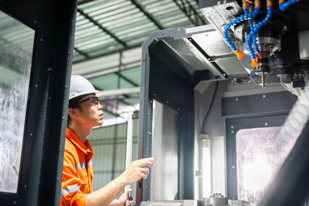 istock Hispanic technician showcasing mastery in configuring a cutting-edge CNC milling machine for precision manufacturing. 2052100451