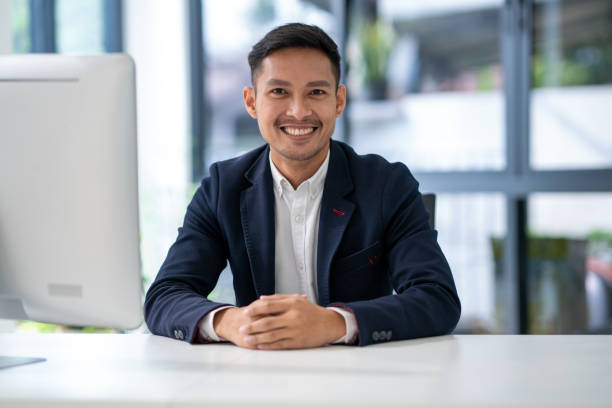 Asian man office worker portrait sitting on desk office