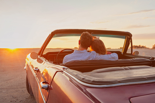 luxury, romantic couple in vintage classic cabriolet car at sunset