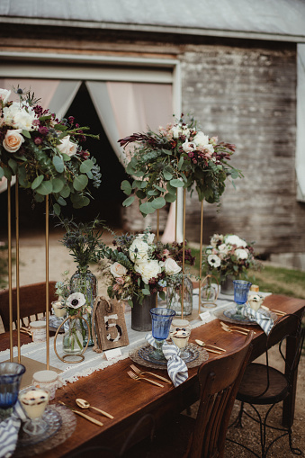 Farm wedding with table outdoors and flower centerpieces