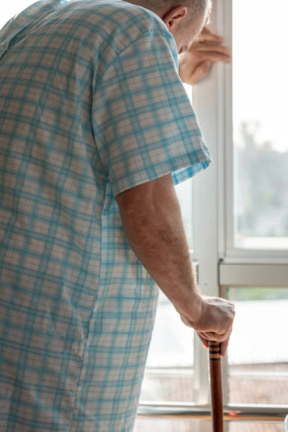 istock Old sick man standing leaning on his cane 2052209004