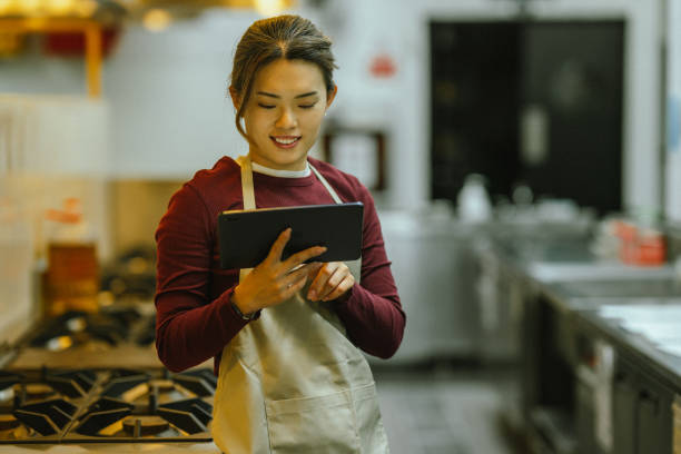 istock Tech-Infused Learning: Asian Female Trainee Excels in Culinary Mixing 2052260624