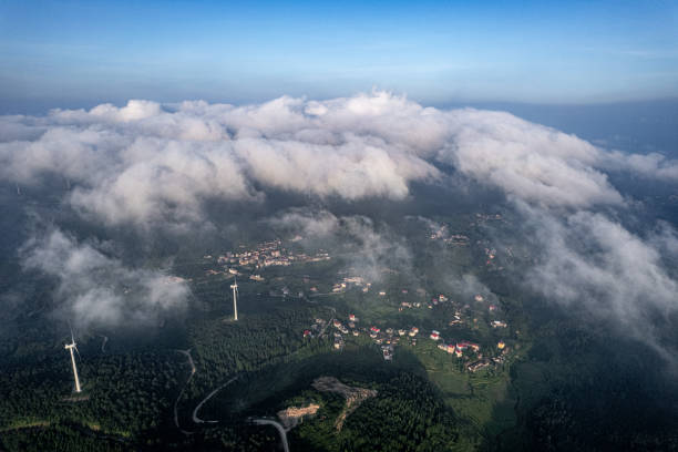 istock Cloudy and foggy mountains and wind turbine clusters 2052274140