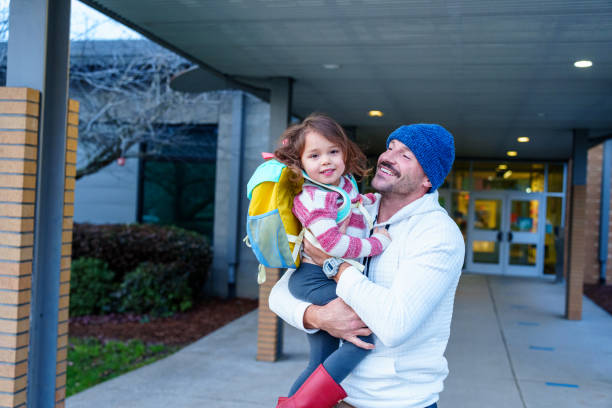 Loving dad picking daughter up from school