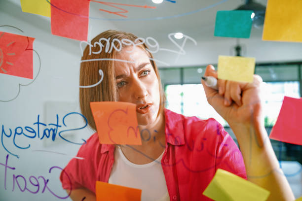 istock Young beautiful business leader writing marketing idea on board. Immaculate. 2052336615
