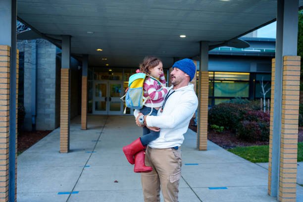 istock Loving dad picking daughter up from school 2052336617