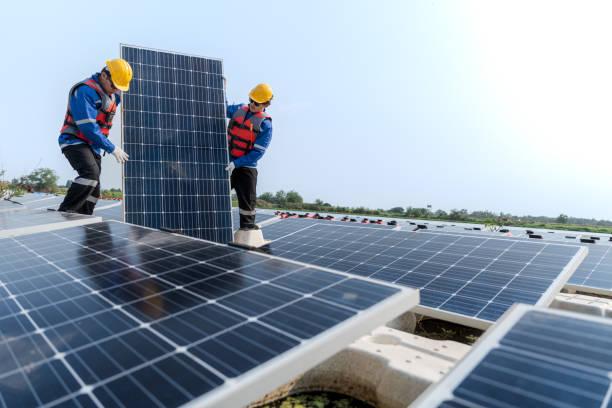 istock Male workers repair Floating solar panels on water lake. Engineers construct on site Floating solar panels at sun light. clean energy for future living. Industrial Renewable energy of green power. 2052346464