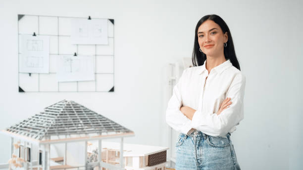 istock Young beautiful architect poses confidently with house model. Immaculate. 2052348030