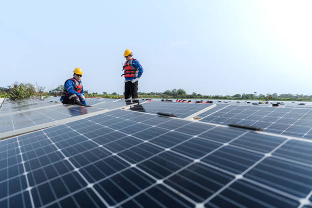 istock Male workers repair Floating solar panels on water lake. Engineers construct on site Floating solar panels at sun light. clean energy for future living. Industrial Renewable energy of green power. 2052352172