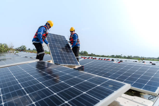 istock Male workers repair Floating solar panels on water lake. Engineers construct on site Floating solar panels at sun light. clean energy for future living. Industrial Renewable energy of green power. 2052353771