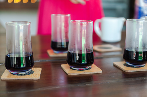 four glasses on the wooden coasters sit on the table