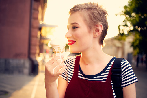 pretty woman outdoors eating ice cream walk. High quality photo