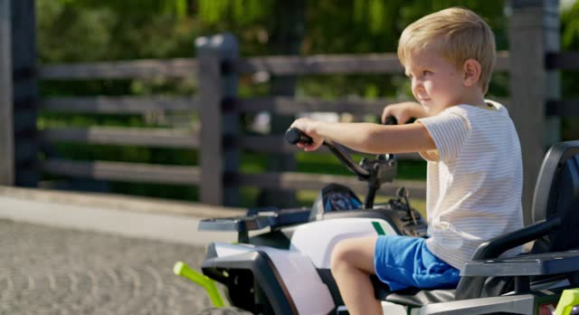 Young Boy Enjoying Ride in Electric Toy Car