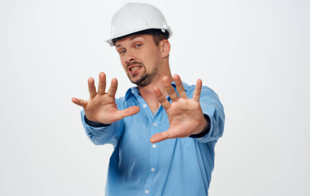 istock Emotional architect builder in a white helmet and in a blue shirt on an isolated background 2052394573