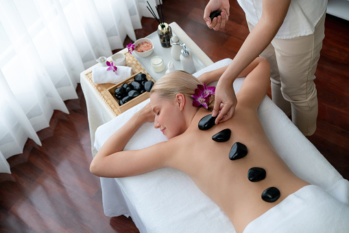 Close-up shot of a woman enjoying relaxing back and shoulder massage at spa.