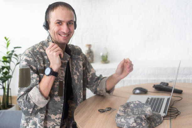 istock Young hispanic man army soldier using laptop sitting on table at home 2052457848