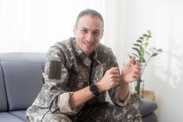 istock excited army soldier sitting on couch at home 2052464701