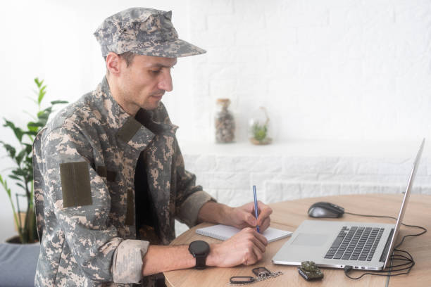 istock Young hispanic man army soldier using laptop sitting on table at home 2052468914