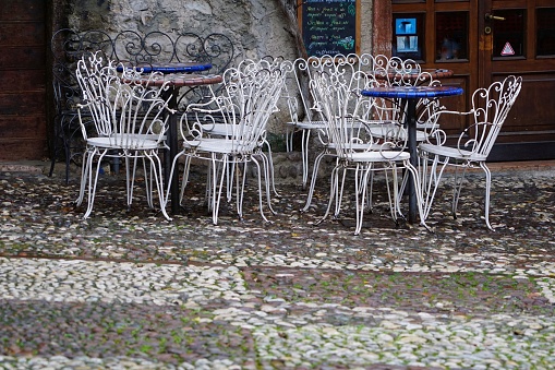 An empty street cafe with chairs. A beautiful deserted street cafe. Empty chairs of an outdoor cafe after the rain.