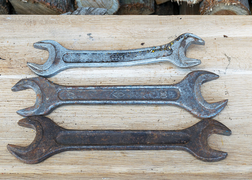 Antique wrenches on a wooden background, rusty tools, metal waste, scrap metal, wrench collection