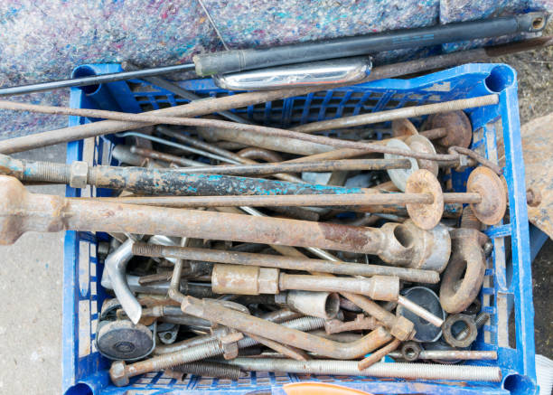 metal waste bin, container full of various iron waste, rusty old antique iron tools, scrap metal