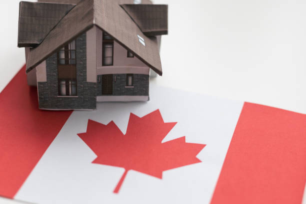 istock Small house on a flag - Living or migrating to Canada 2052500243