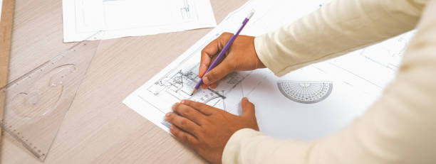 istock Cropped image of skilled engineer hand draws blueprint. Back view. Variegated. 2052502966