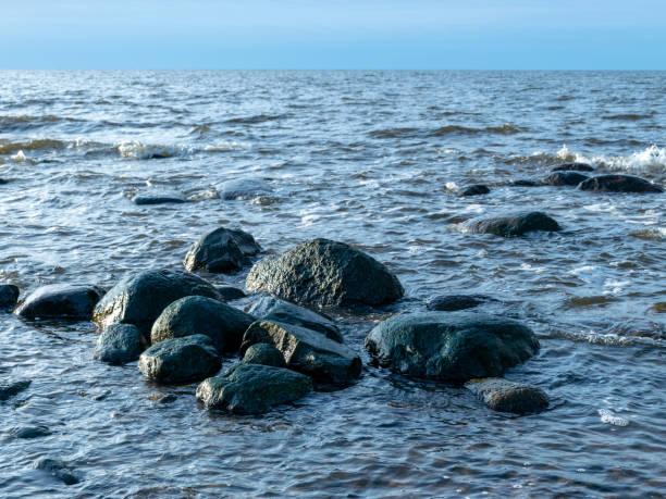 istock landscape with stony beach and lonely man silhouette in the evening 2052504816