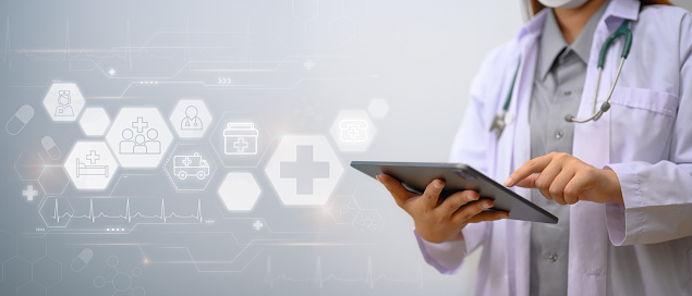 Medical technology concept. Doctor in white coat using digital tablet with medical icons network connection.
