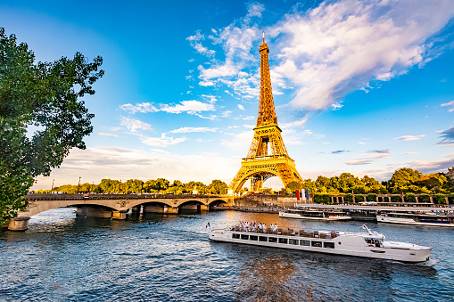 Scenic panorama of Eiffel Tower, Seine River, and pont d'lena in Paris, France; with a cruise passing by