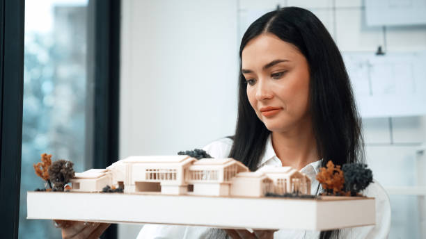 istock Skilled caucasian architect lift house model to check mistake point. Immaculate. 2052535122