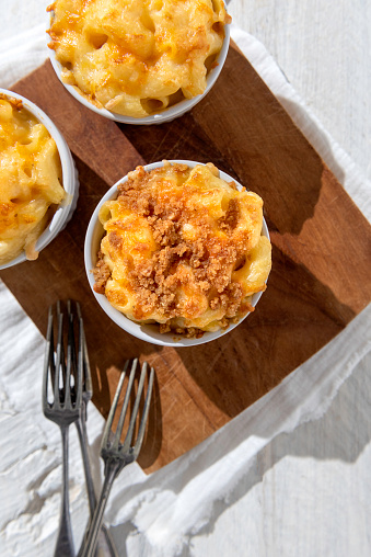 Baked macaroni and cheese on a wihte rustic background