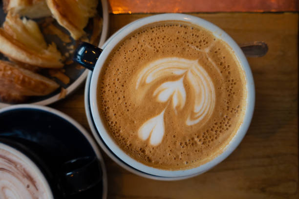 istock Latte art and Coffee Cups with Cinnamon on the Table, accompanied by Saucer, Spoon, and Sugar a delightful morning beverage scene at the cafe 2052558281