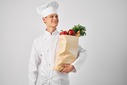 a man in a chef's uniform a package of products work service. High quality photo