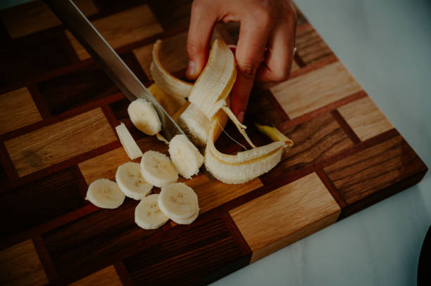 istock A woman cuts a banana into small pieces and grabs a fresh healthy nutritious breakfast full of vitamins 2052577498