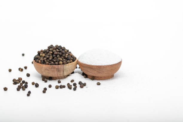 istock Isolated black peppercorns next to fine grain table salt 2052579596
