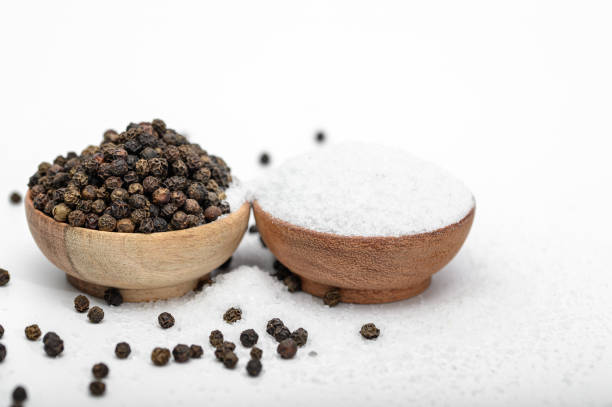 Salt and pepper, spices in bowls on white background close-up isolated