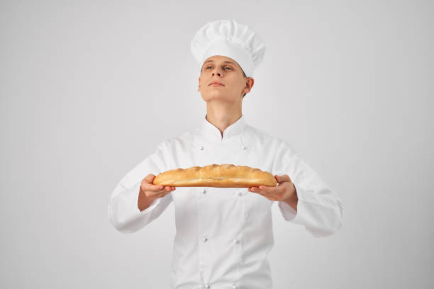 man in chef's clothes Professional with a baguette in his hands fresh product work. High quality photo