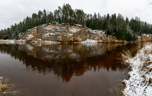 panoramic view of sandstone outcrop on the opposite bank of the river, river gauja in December, Cesis, Erglu cliffs, Latvia