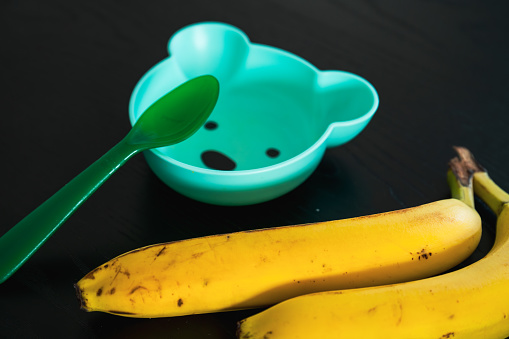 Banana and baby bowl in the shape of a bear. Feeding a toddler with fruit