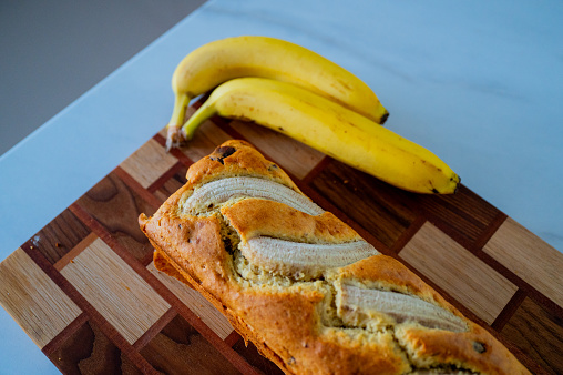 On the kitchen counter: banana bread and a ripe banana in natural daylight