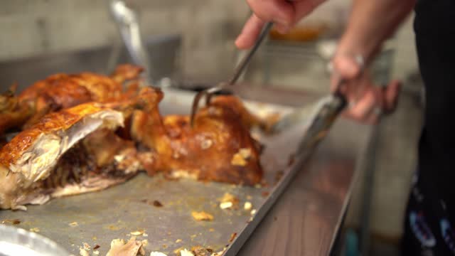 close up of a person cutting roast chicken