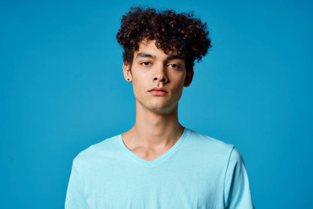 istock guy with curly hair in blue t-shirt cropped view studio 2052640598