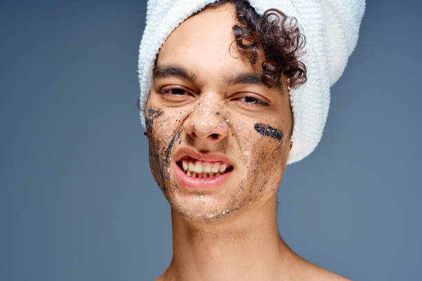 istock cute guy with a towel on his head face cream skin care 2052643714